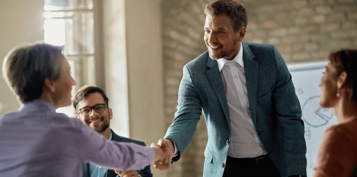 Business Coworkers Shaking Hands During A Meeting In The Office Focus Is On A Businessman 1
